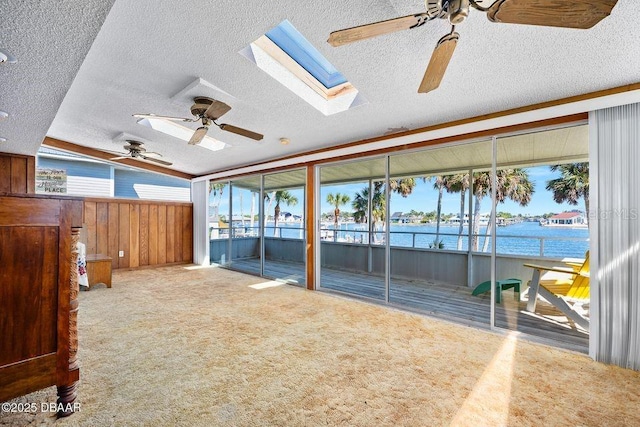 interior space with ceiling fan and a water view