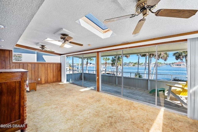 interior space featuring a textured ceiling, wood walls, and a ceiling fan