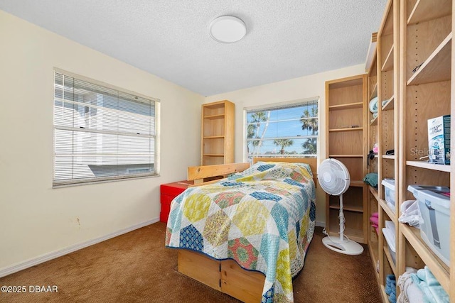 carpeted bedroom with baseboards and a textured ceiling