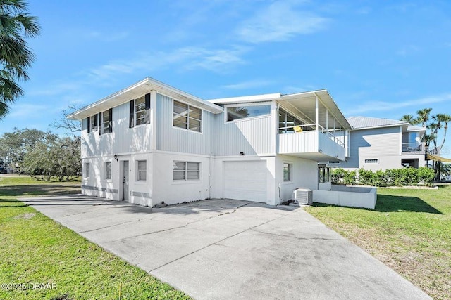 view of side of home with a garage, a lawn, concrete driveway, a balcony, and cooling unit