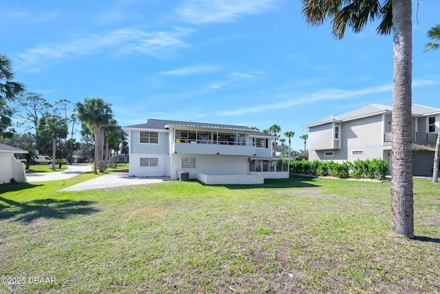 back of house with a lawn and a sunroom