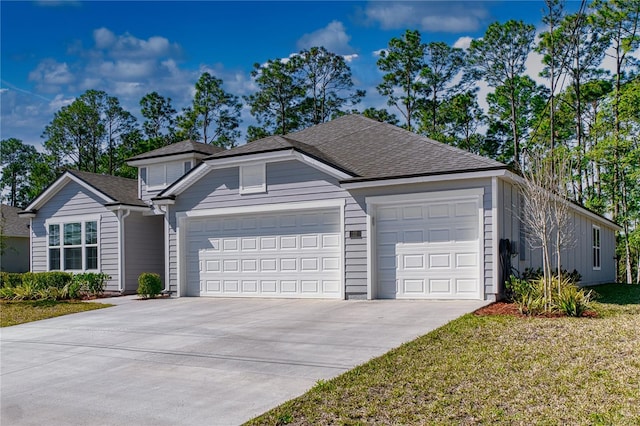 view of front facade featuring a garage, driveway, a front lawn, and roof with shingles