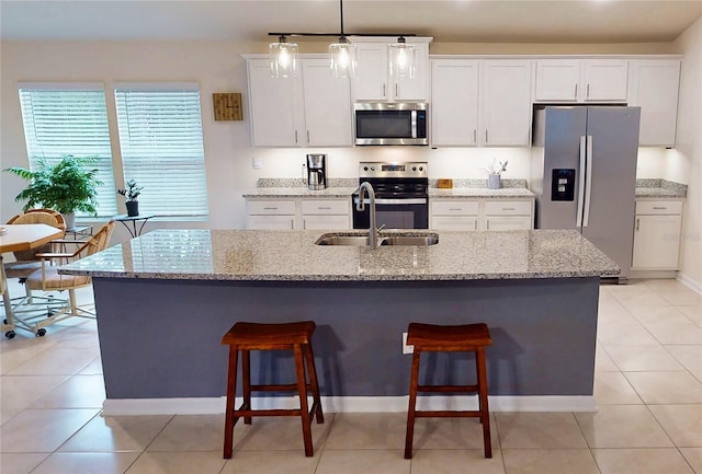 kitchen with white cabinets, stainless steel appliances, and a kitchen breakfast bar