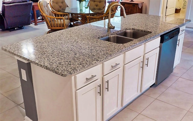 kitchen featuring light stone counters, light tile patterned flooring, a sink, white cabinetry, and dishwashing machine