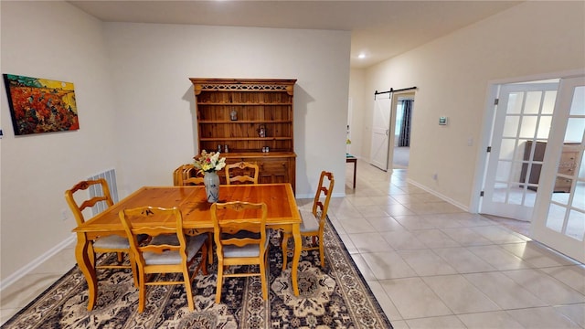 dining space with plenty of natural light, a barn door, baseboards, and light tile patterned flooring