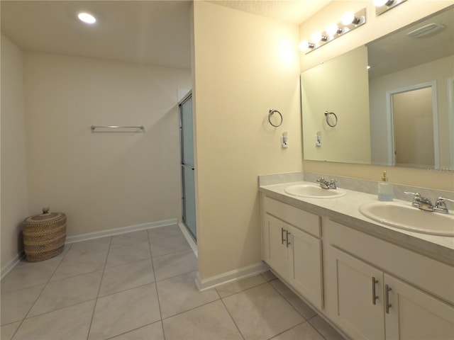 bathroom with tile patterned flooring, a sink, a shower with door, and baseboards