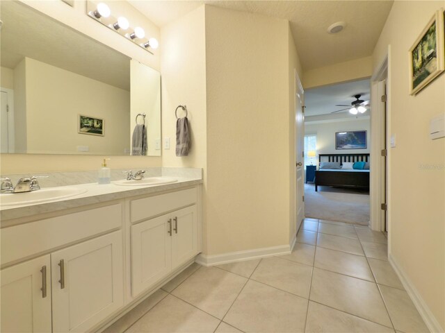 full bathroom with double vanity, connected bathroom, a sink, and tile patterned floors