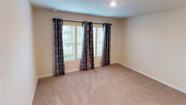 carpeted empty room with baseboards