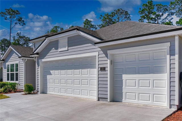 view of front facade featuring a garage, concrete driveway, and a shingled roof