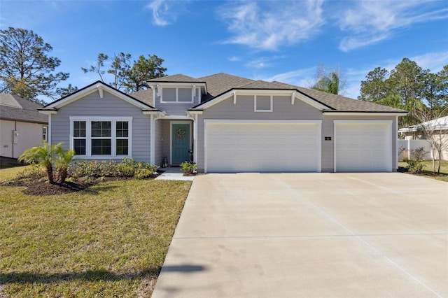 view of front of house with a garage, driveway, a shingled roof, and a front yard