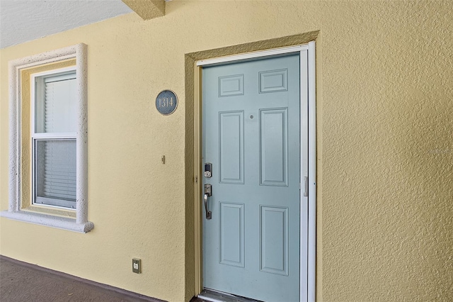 view of exterior entry with stucco siding