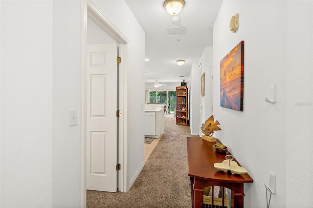 hallway featuring light colored carpet