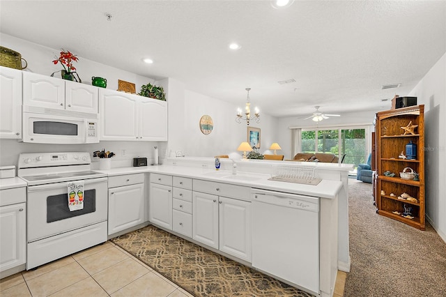 kitchen with a peninsula, white appliances, white cabinets, and open floor plan