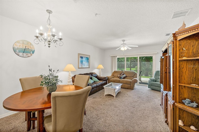 living room with a textured ceiling, ceiling fan with notable chandelier, carpet floors, visible vents, and baseboards