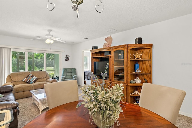 dining space with ceiling fan and a textured ceiling