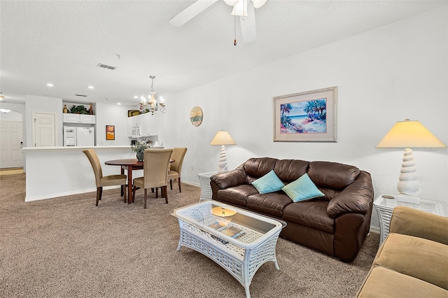 living area featuring light carpet, baseboards, a textured ceiling, and ceiling fan with notable chandelier