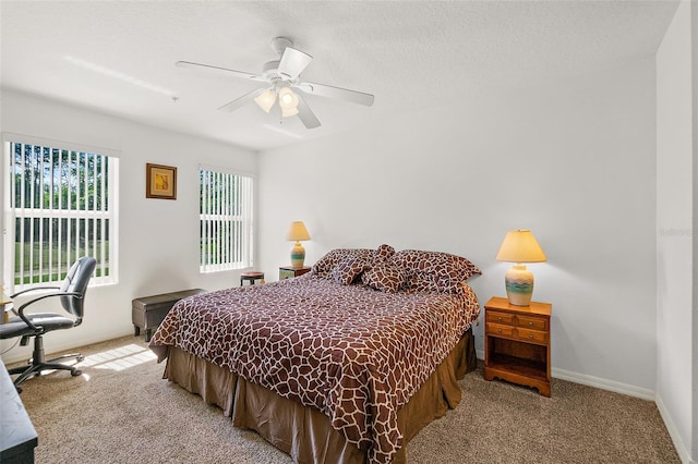 bedroom featuring baseboards, a textured ceiling, a ceiling fan, and light colored carpet