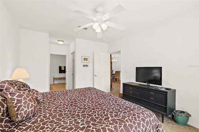 carpeted bedroom featuring ceiling fan and ensuite bath