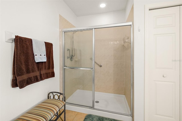 full bath featuring tile patterned flooring and a shower stall