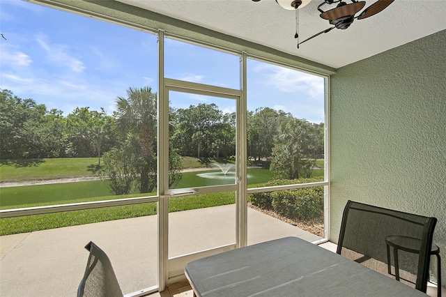 unfurnished sunroom featuring a ceiling fan