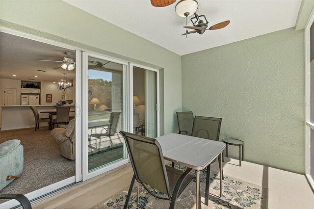 sunroom with ceiling fan with notable chandelier