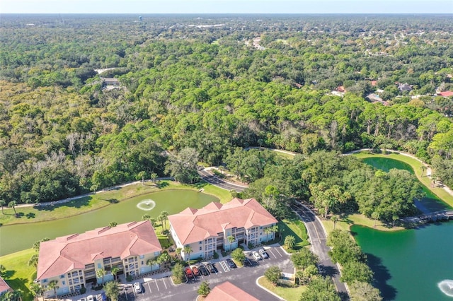 drone / aerial view with a water view and a forest view