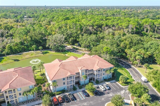 birds eye view of property featuring a water view and a view of trees