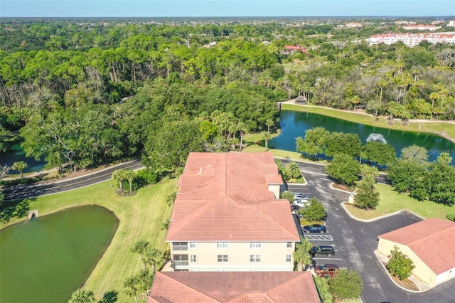 bird's eye view with a water view and a wooded view