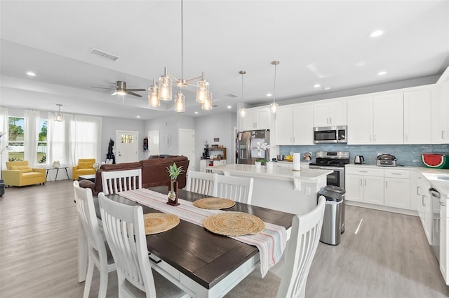 dining room with light wood-type flooring, ceiling fan, visible vents, and recessed lighting