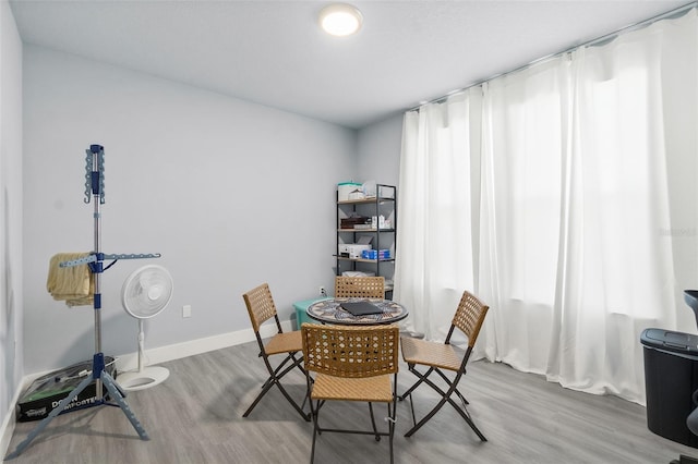 dining space featuring light wood-style floors and baseboards