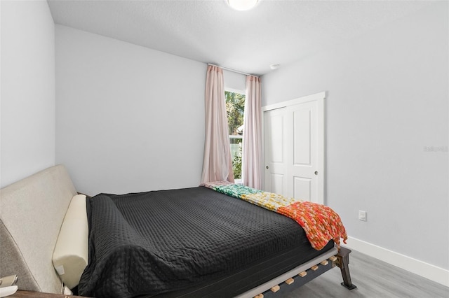 bedroom with wood finished floors and baseboards