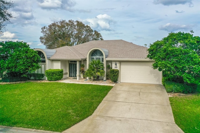 view of front of property with a garage, a shingled roof, driveway, stucco siding, and a front yard