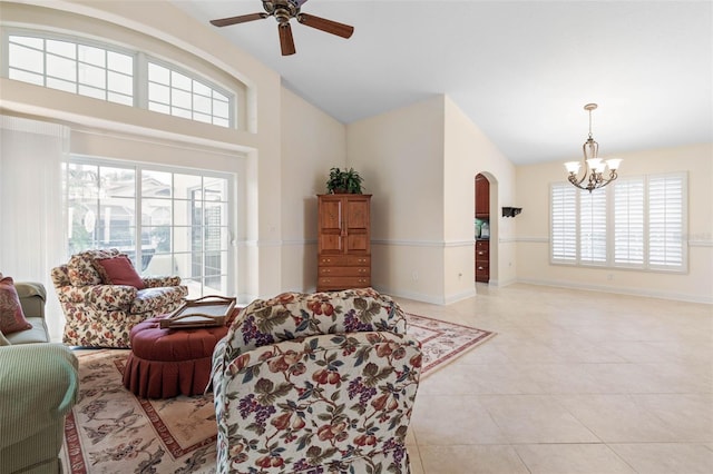 living area with baseboards, arched walkways, light tile patterned flooring, high vaulted ceiling, and ceiling fan with notable chandelier