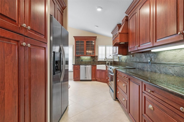 kitchen featuring tasteful backsplash, custom exhaust hood, vaulted ceiling, stainless steel appliances, and a sink