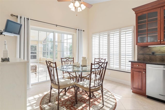 dining room with ceiling fan, baseboards, and light tile patterned floors