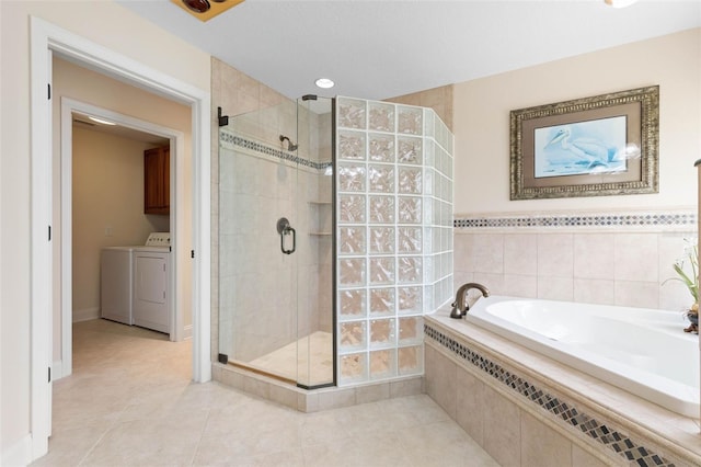 bathroom with separate washer and dryer, a shower stall, a bath, and tile patterned floors