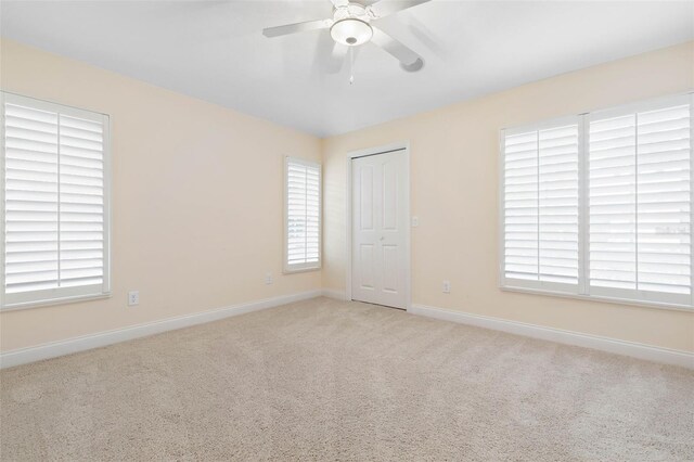 unfurnished room featuring light carpet, ceiling fan, and baseboards