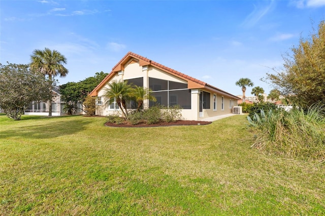 back of property with a tiled roof and a lawn