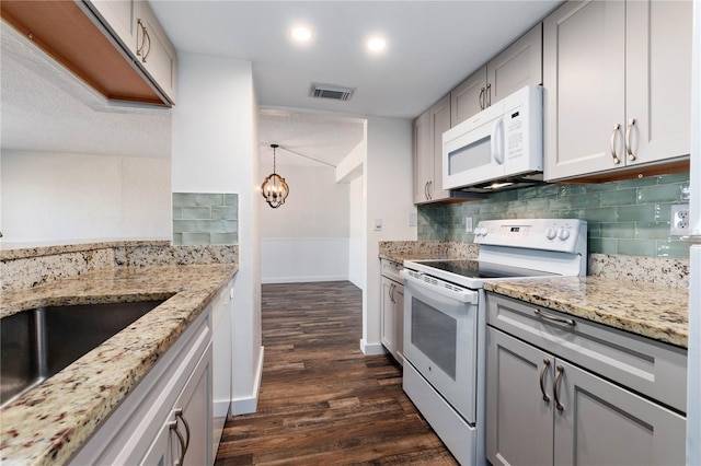 kitchen featuring white appliances, visible vents, gray cabinets, and decorative backsplash