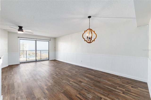 unfurnished room with dark wood-style floors, wainscoting, a textured ceiling, and ceiling fan with notable chandelier