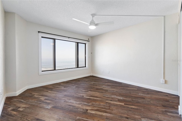 spare room with dark wood-style floors, a textured ceiling, baseboards, and a ceiling fan