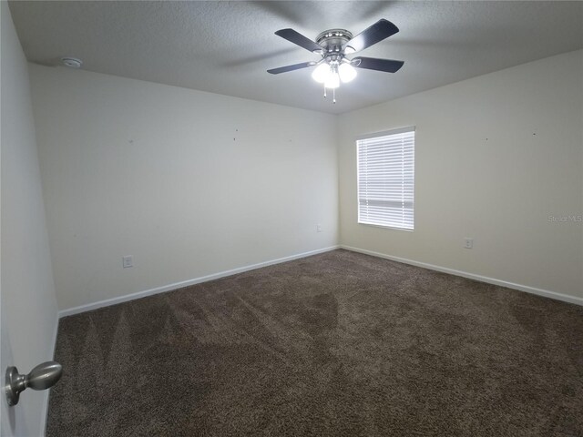 carpeted spare room with ceiling fan, baseboards, and a textured ceiling