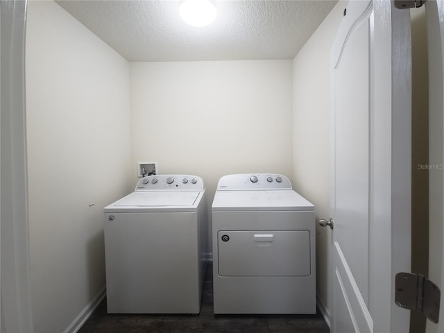 laundry room featuring a textured ceiling, laundry area, separate washer and dryer, and dark wood-style floors