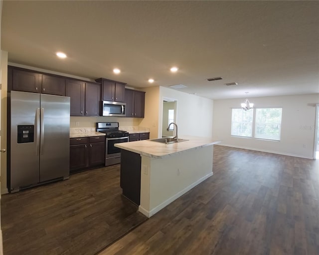 kitchen with stainless steel appliances, a sink, visible vents, dark brown cabinets, and light countertops