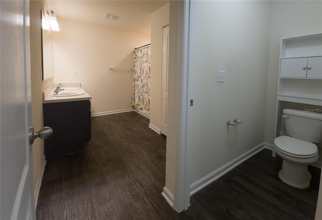 bathroom with toilet, baseboards, wood finished floors, and vanity