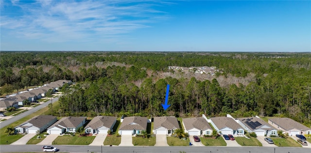 drone / aerial view featuring a residential view and a wooded view