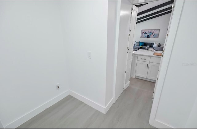 washroom featuring laundry area, light wood finished floors, and baseboards