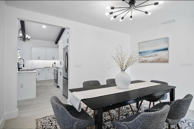 dining area featuring an inviting chandelier, visible vents, and light wood finished floors