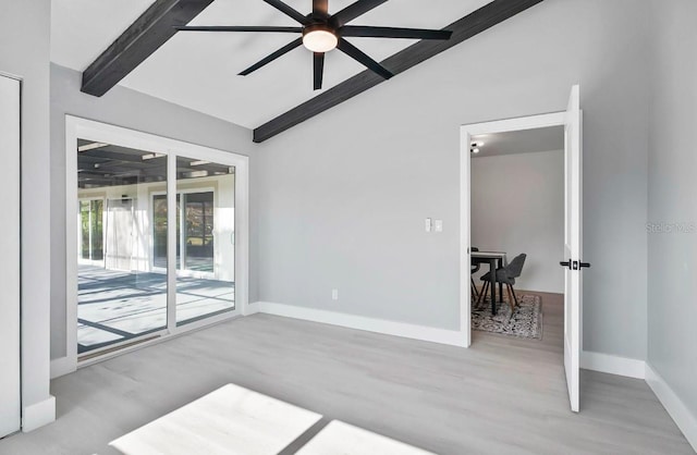 spare room featuring vaulted ceiling with beams, wood finished floors, a ceiling fan, and baseboards