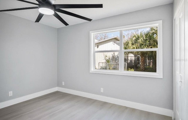 empty room featuring ceiling fan, baseboards, and wood finished floors